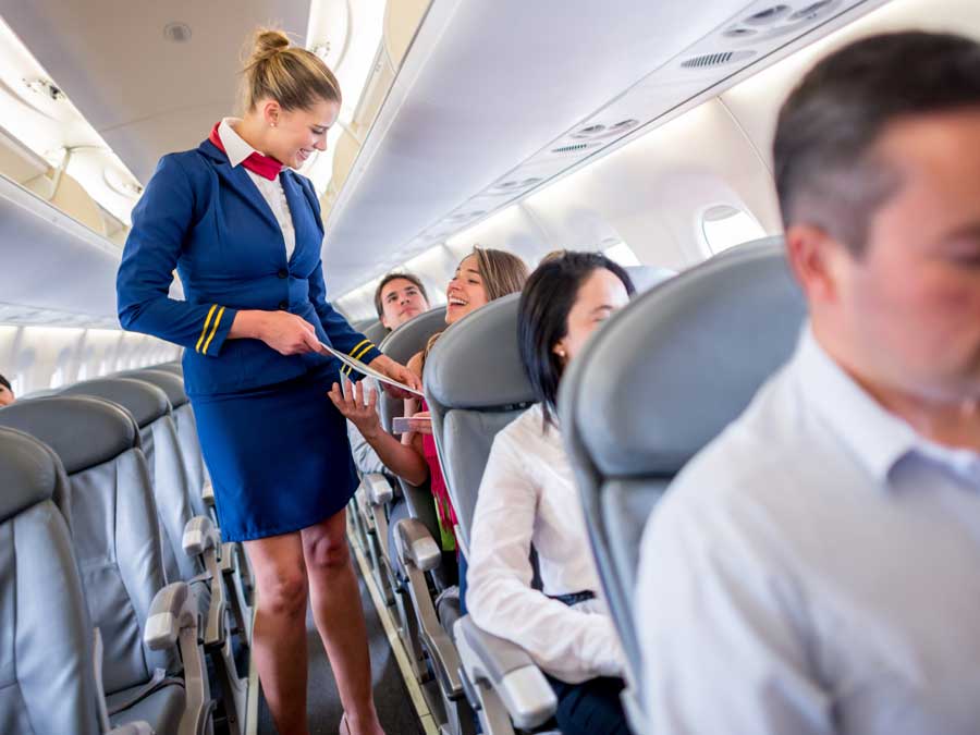 A flight attendant assisting a passenger