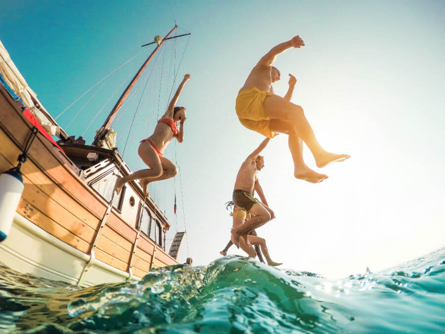 Friends jumping off a boat