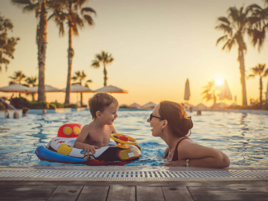 Mother and son swimming in a resort pool