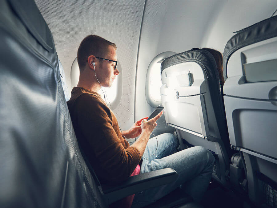 An airplane passenger listening to music