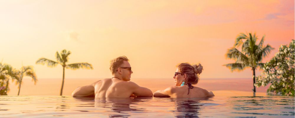 Couple looking at sunset in pool