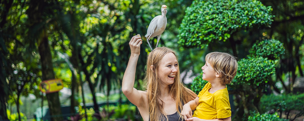 Mother holding child with bird on her head