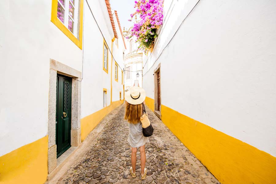 woman walking through the narrow street in the old town of Evora in Portugal