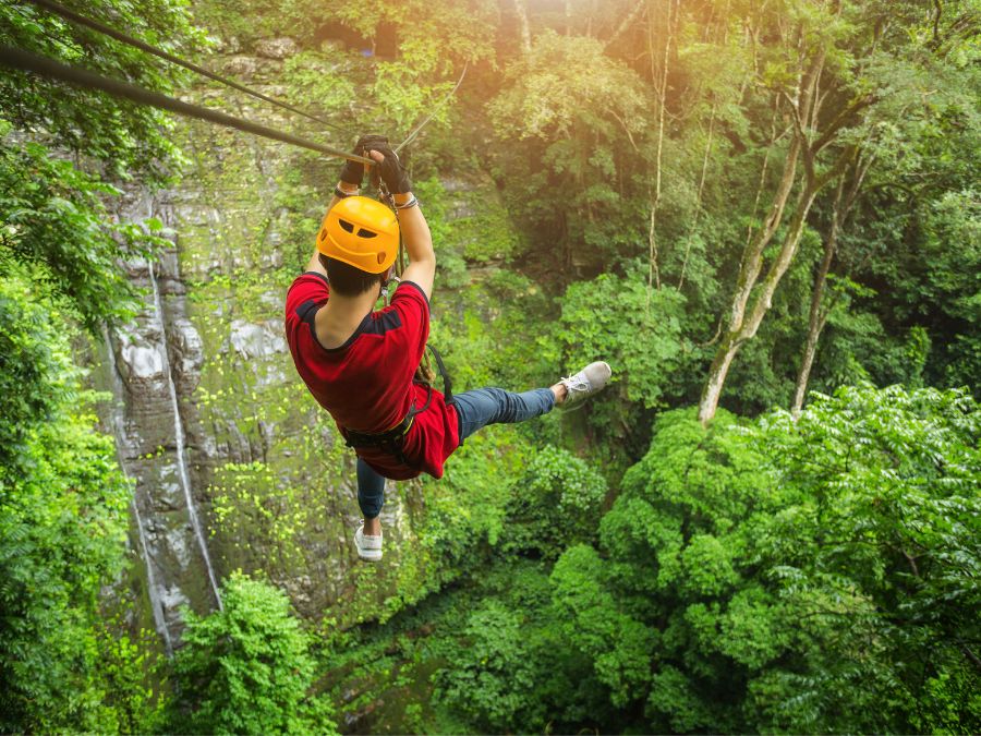 A teenager ziplining in the forest