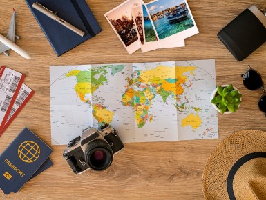 Map of the world, camera and passport on table