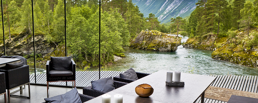 Table and chairs overlooking river and mountains