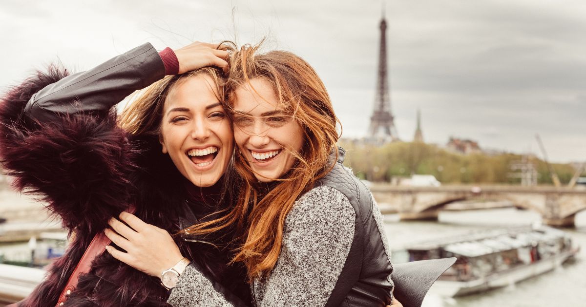 Women taking photo in front of Eiffel Tower in Paris