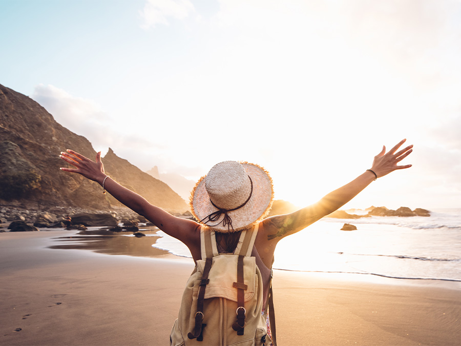 Person with their arms out on beach