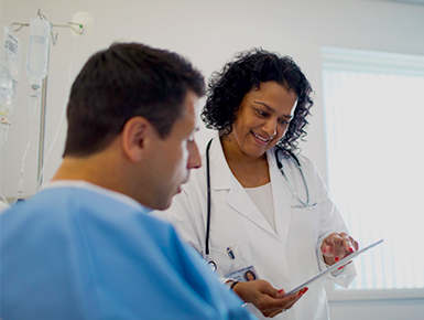 Man sitting in hospital bed talking to doctor