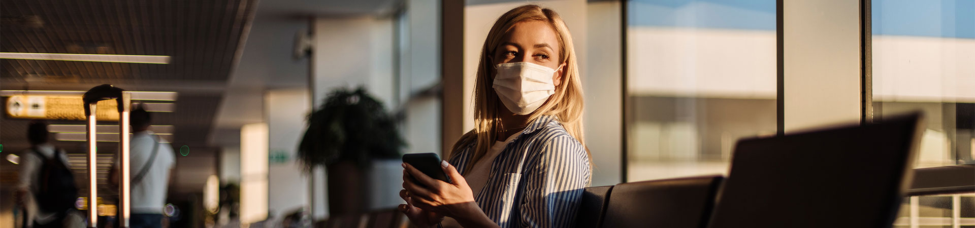 A woman in the airport wearing a Covid mask.