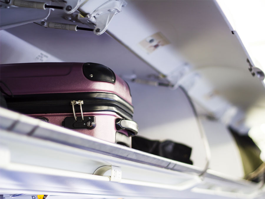 Suitcase in an overhead cabin storage inside the plane